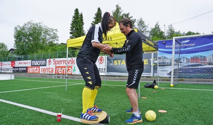 Cathrine er aktiv på både fotball- og handball-laget. Her øver ho balanse saman med handballsjef Christian Bugge. (Foto: Kjetil Vasby Bruarøy)