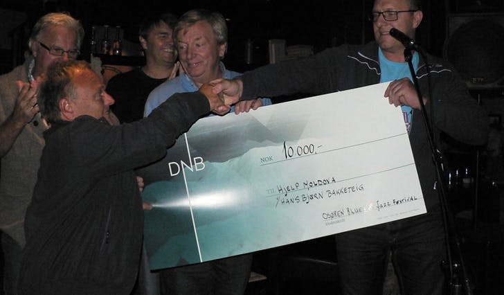 Ein rørt Hans Bjørn Bakketeig tok imot gåva på 10.000 kroner frå resten av styret i Osøren Blues og Jazzfestival (foto: Ingunn E. Bakketeig, OBJF)