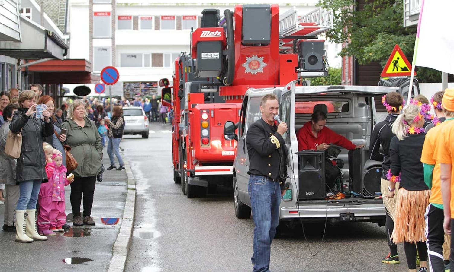 Rune Nilsen med mikrofon under dragebåt-parade gjennom Osøyro. (Foto: Kjetil Vasby Bruarøy)